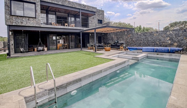 Modern home with a private pool, hot tub, outdoor kitchen, & mountain views